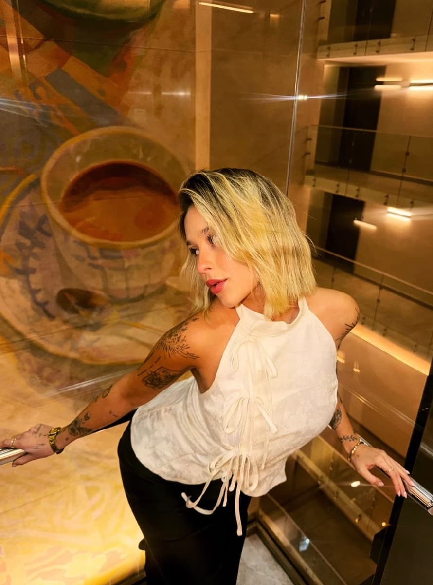 Antonia Jesús con blusa blanca junto a una taza de café.