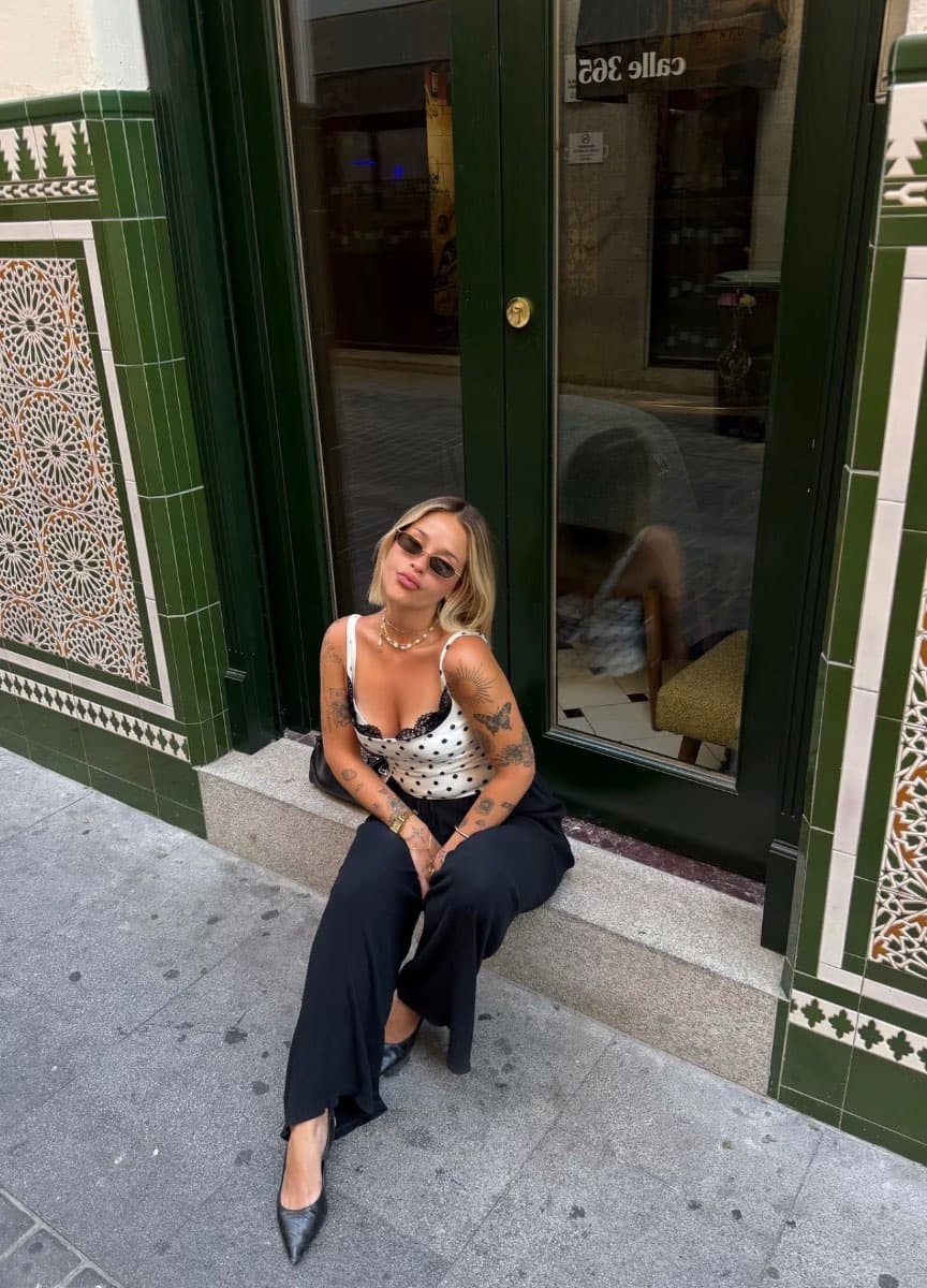 Antonia Jesús sentada en la entrada de un local de azulejos verdes.
